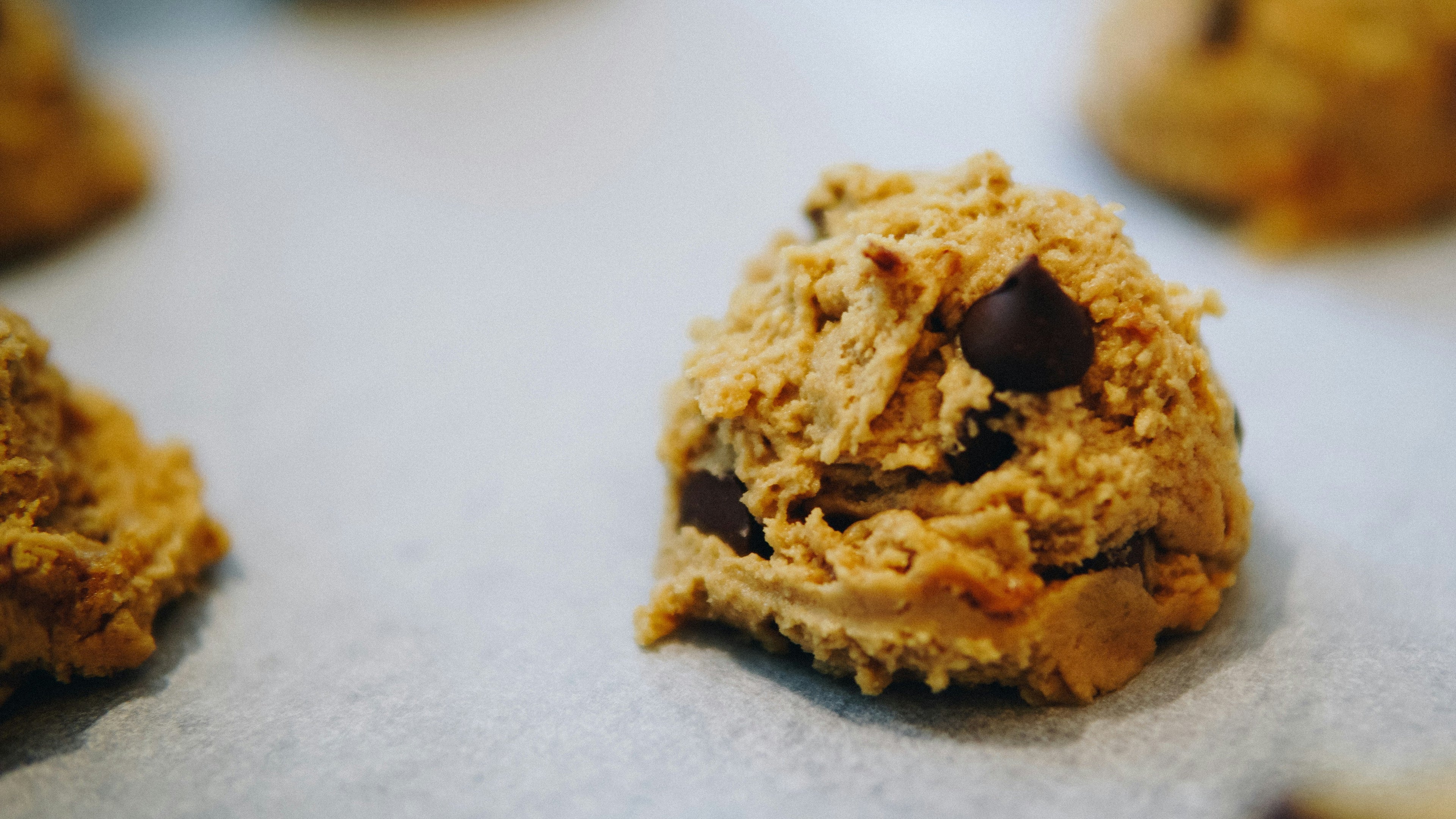 Unbaked cookie with chocolate chips on a baking sheet
