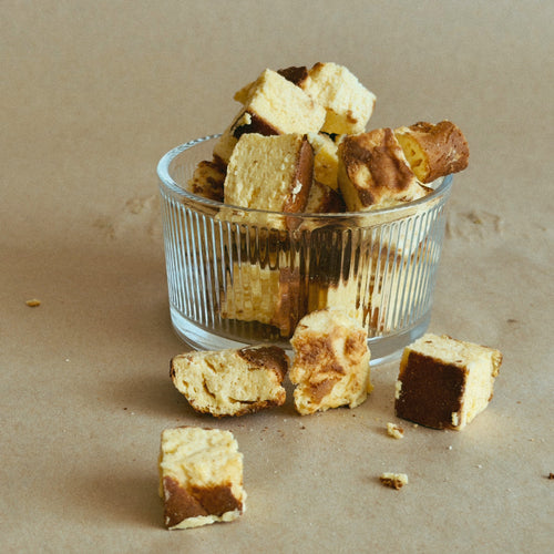 Freeze dried Basque Cheesecake pieces in a glass ramekin.  
